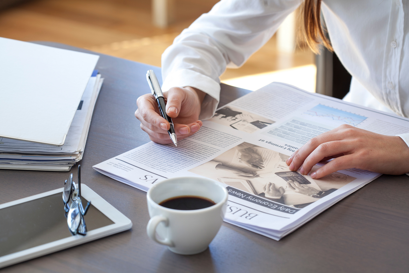 Woman reading newspaper on table